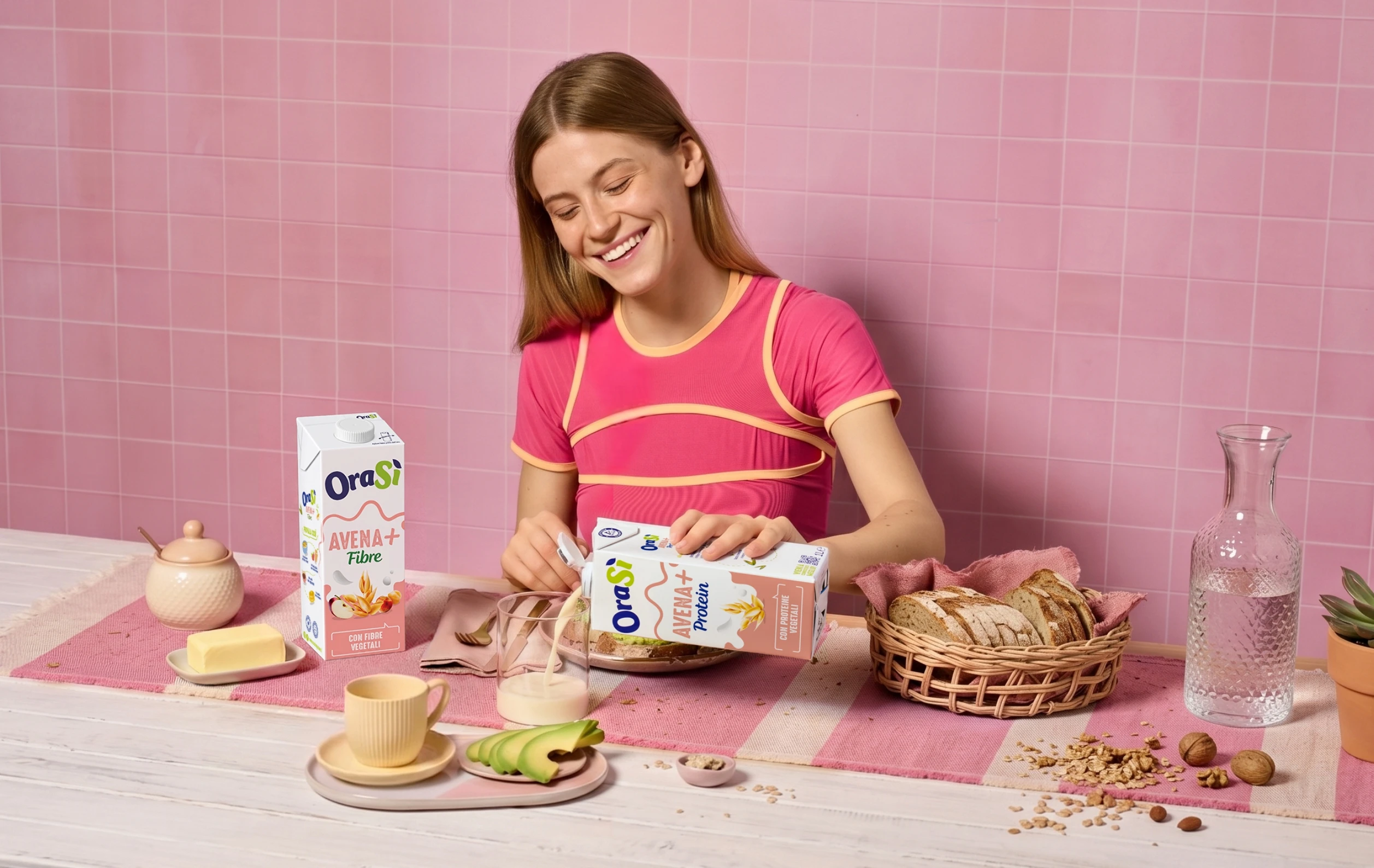Ragazza che versa bevanda OraSì all'avena + protein su una tovaglia su uno sfondo rosa